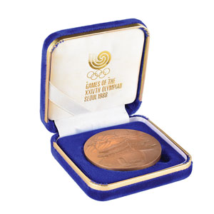 Lot #3114  Seoul 1988 Summer Olympics Bronze Participation Medal and Press Medal with Cases - Image 1